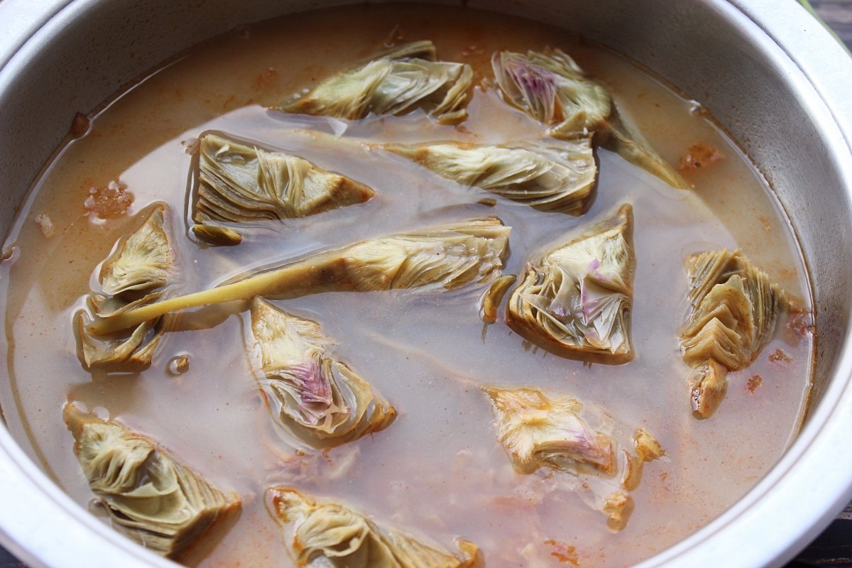 Adición del fumet de pescado a las alcachofas rehogadas