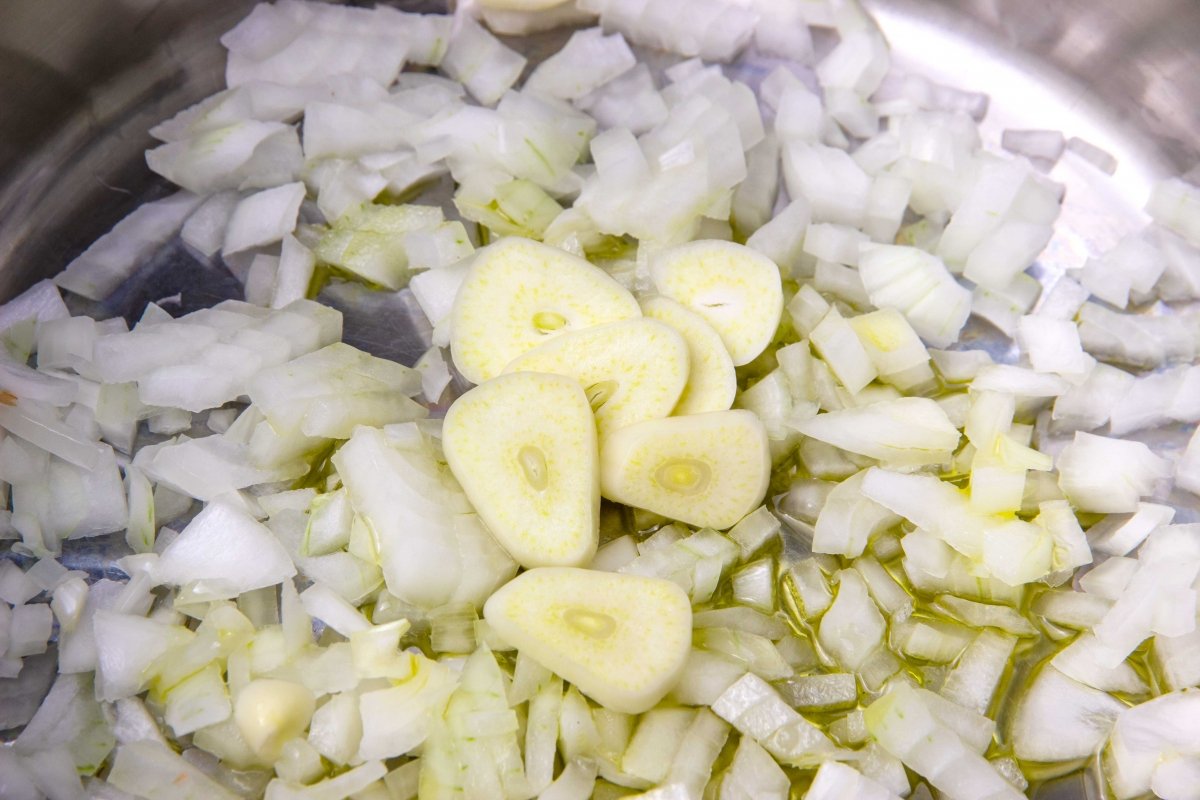 Pochar ajo y cebolla para la salsa de champiñones